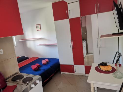 een kleine kamer met een bed en een keuken bij Apartments Coso Zlatne njive bb in Kotor