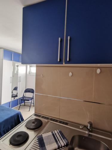 a kitchen with a stove and a blue cabinet at Apartments Coso Zlatne njive bb in Kotor