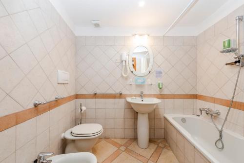 a bathroom with a toilet and a sink and a bath tub at Hotel Ristorante Maga Circe in San Felice Circeo