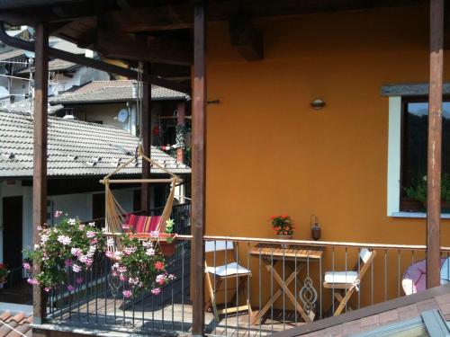 a balcony of a house with two chairs and flowers at B&B Il Castello Lago Maggiore con TERRAZZA in Cossogno