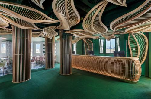 a room with columns in a building with green floors at Room Mate Macarena – Gran Vía in Madrid