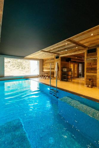 une grande piscine bleue dans un immeuble dans l'établissement Hotel Le V de Vaujany, à Vaujany