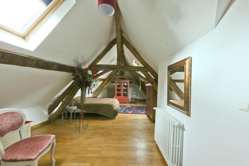 a attic room with a bed and a window at Chambre Pasta - Moulin de Gâteau in Saint-Pierre-les-Étieux