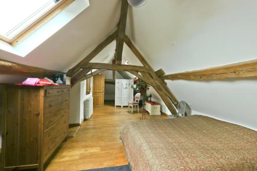 1 dormitorio con 1 cama en una habitación con vigas de madera en Chambre Pasta - Moulin de Gâteau, en Saint-Pierre-les-Étieux
