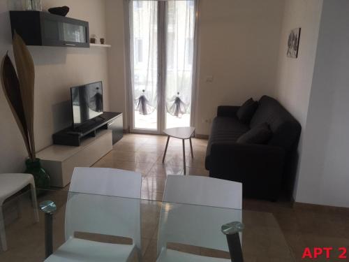 een woonkamer met een glazen tafel en een bank bij Agnese Apartments in Diano Marina