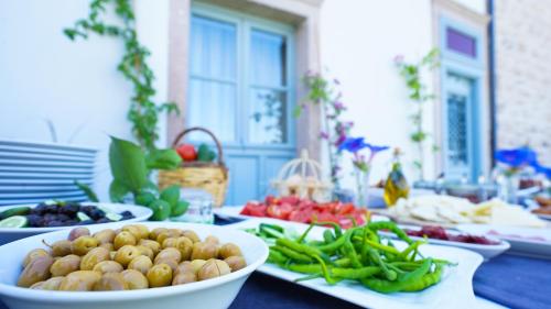 a table with plates of fruits and vegetables on it at Cunda Ömer Ağa Konağı in Cunda