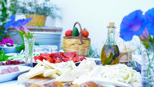 a table with cheese and vegetables and a bottle of wine at Cunda Ömer Ağa Konağı in Cunda