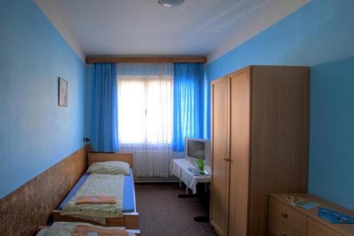 a hotel room with two beds and a window at Penzion Menšík in Kroměříž