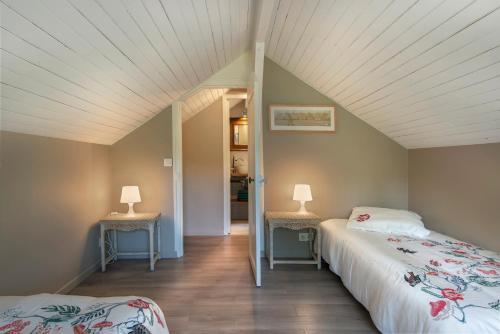 a bedroom with two beds and two lamps on tables at La Petite Affolante in Samois-sur-Seine