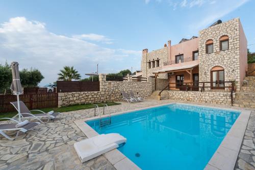 een villa met een zwembad en een gebouw bij Villas Delight in Sitia