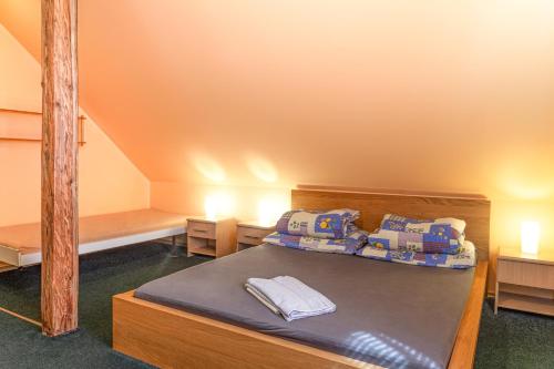 a bedroom with a bed with two tables and a staircase at Pěkná Vyhlídka in Závažná Poruba
