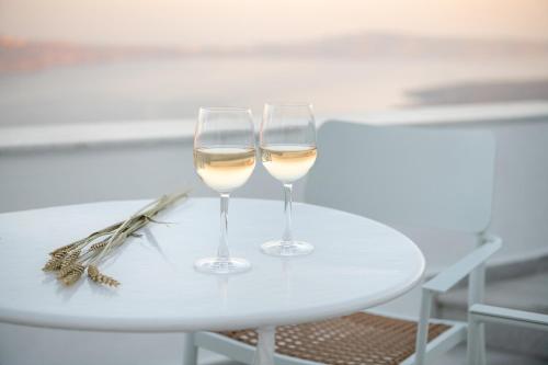 two glasses of white wine sitting on a table at Veranda View in Imerovigli