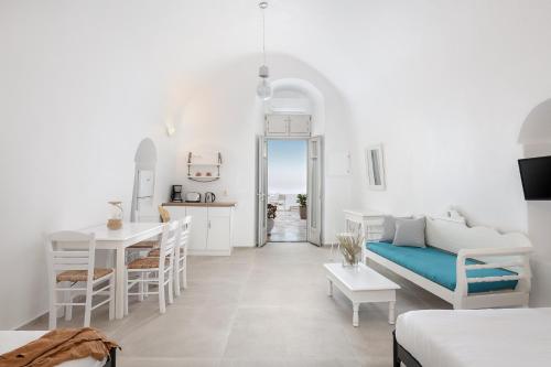 a white living room with a couch and a table at Veranda View in Imerovigli