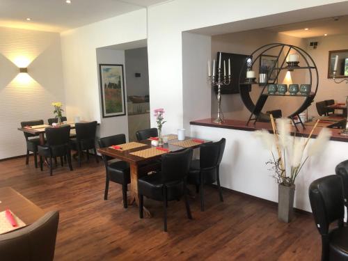a dining room with tables and chairs and a mirror at WH Hotels Papenburg Zentrum in Papenburg
