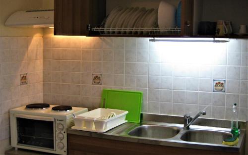 een keuken met een wastafel en een magnetron bij Studio in Pelekas in Pelekas