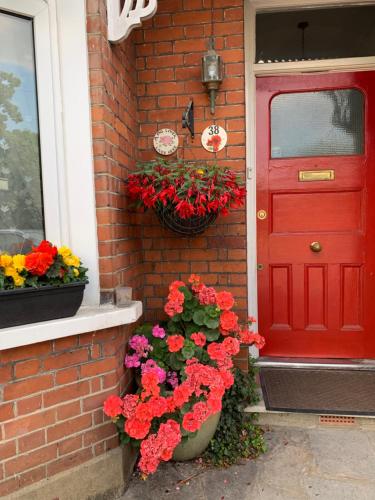 a red door with flowers on a brick house at 38 Whitehall Road in Harrow on the Hill