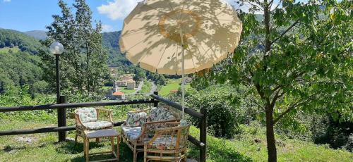a couple of chairs and an umbrella on a balcony at Ca' du Tu in Masone
