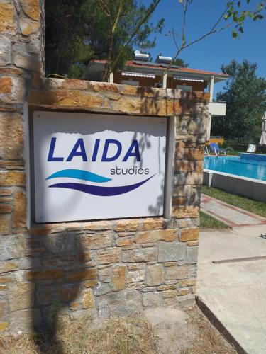 una señal para los estudios Alda en una pared de piedra en Laida studios, en Prinos
