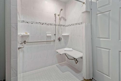 a white bathroom with a shower and a sink at La Quinta by Wyndham Brownsville North in Brownsville