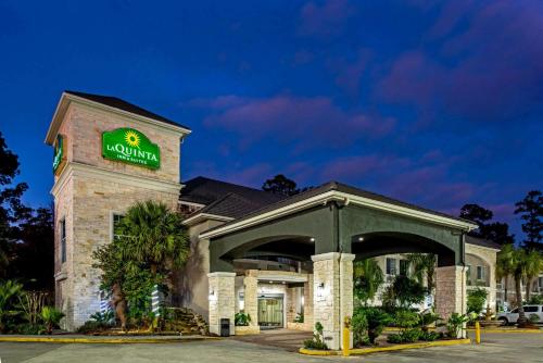 a hotel with a sign on the front of a building at La Quinta Inn & Suite Kingwood Houston IAH Airport 53200 in Kingwood