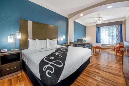 a hotel room with a bed and a dining room at La Quinta Inn & Suite Kingwood Houston IAH Airport 53200 in Kingwood
