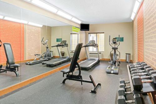 a gym with treadmills and exercise bikes in it at La Quinta by Wyndham Shawnee in Shawnee