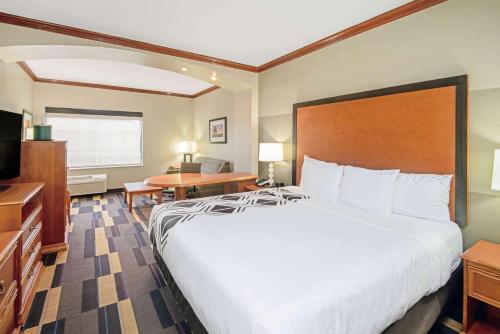 a hotel room with a large bed and a desk at La Quinta by Wyndham Oklahoma City - Moore in Moore