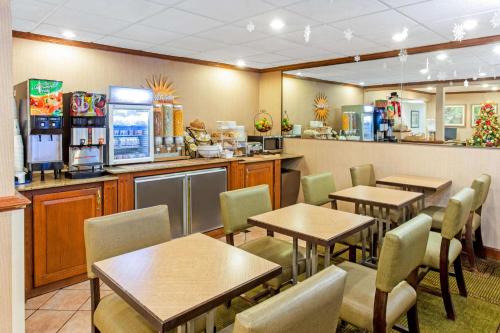 a restaurant with tables and chairs and a counter at La Quinta Inn by Wyndham Milwaukee Airport / Oak Creek in Oak Creek