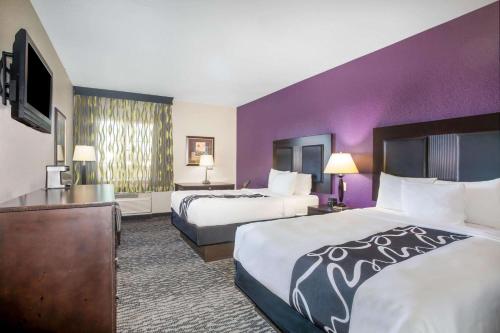 a hotel room with two beds and purple walls at La Quinta by Wyndham Kyle - Austin South in Kyle