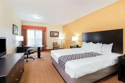 a hotel room with a large bed and a desk at La Quinta by Wyndham Stillwater -University Area in Stillwater