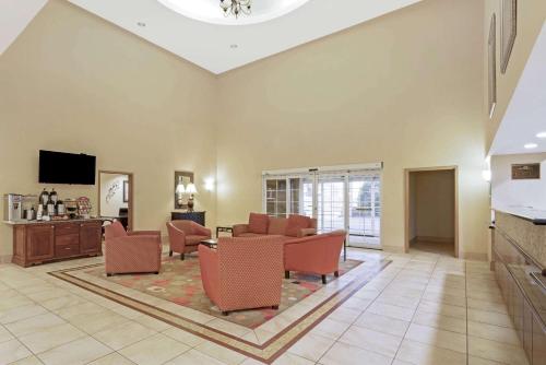 a living room with a couch and chairs and a tv at La Quinta by Wyndham Stillwater -University Area in Stillwater