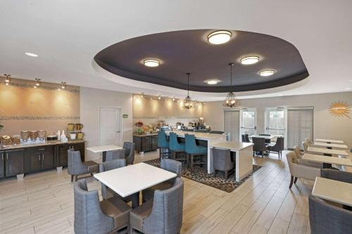 un restaurant avec des tables et des chaises et un bar dans l'établissement La Quinta by Wyndham Houston Energy Corridor, à Houston