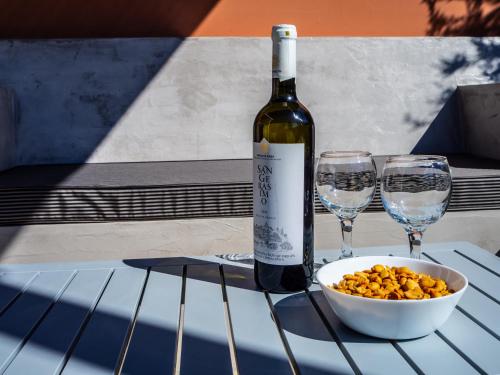a bottle of wine and two glasses on a table at Cypress Garden Villas in Svoronata