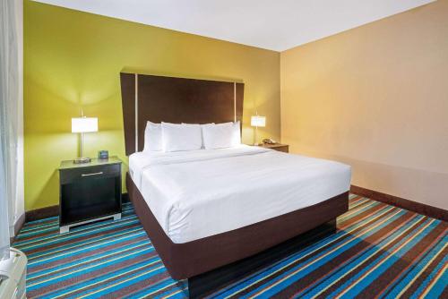 a hotel room with a large bed and a television at La Quinta by Wyndham Muskogee in Muskogee