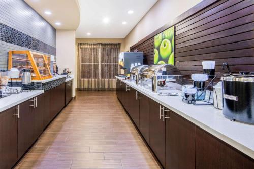 a kitchen with a long counter with a food at La Quinta by Wyndham Clinton Historic Route 66 in Clinton
