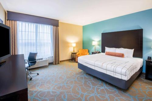 a hotel room with a large bed and a television at La Quinta by Wyndham Clinton Historic Route 66 in Clinton