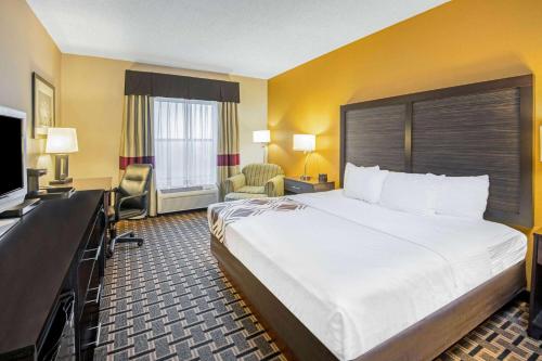 um quarto de hotel com uma cama grande e uma televisão em La Quinta by Wyndham Denison - North Lake Texoma em Denison