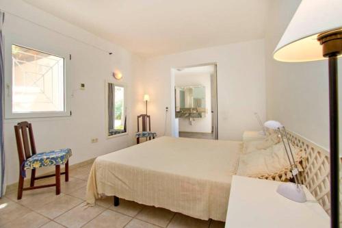 莫甘的住宿－Villa-Tauro Leyh，白色卧室配有床和椅子
