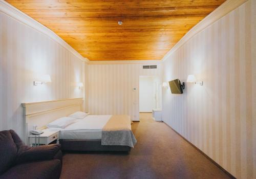 a bedroom with a bed and a wooden ceiling at Premier Geneva Hotel in Odesa