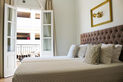 Un dormitorio con una cama grande con almohadas blancas. en 9 Muses Hotel, en Lárnaca