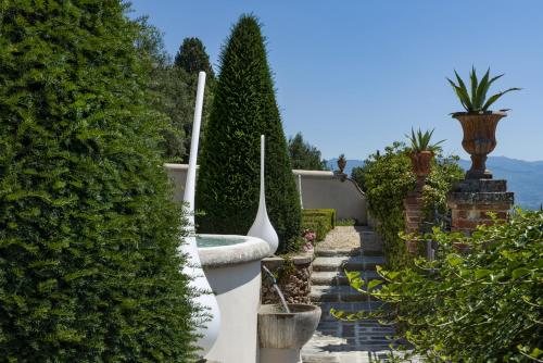 a garden with green bushes and a white fence at Palagina la dimora in Figline Valdarno