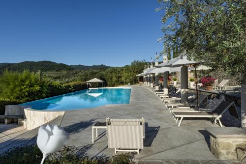 a swimming pool with chairs and umbrellas in a resort at Palagina la dimora in Figline Valdarno
