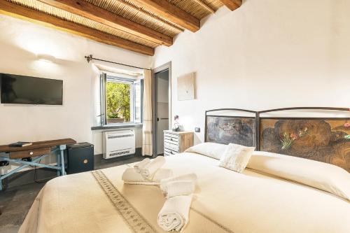 a bedroom with two beds and a tv on the wall at Sa Crai B&B - Sardinian Experience in Lotzorai