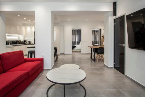 een woonkamer met een rode bank en een tafel bij Emfasis Loft Spacious and Elegant Heraklion in Heraklion