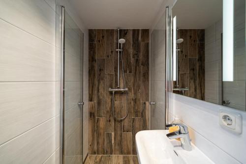 a bathroom with a shower and a sink and a mirror at Haus Windhook in Dierhagen