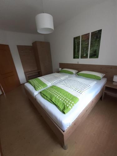 a bedroom with a large bed with green pillows at Landhof Lydia in Roggendorf