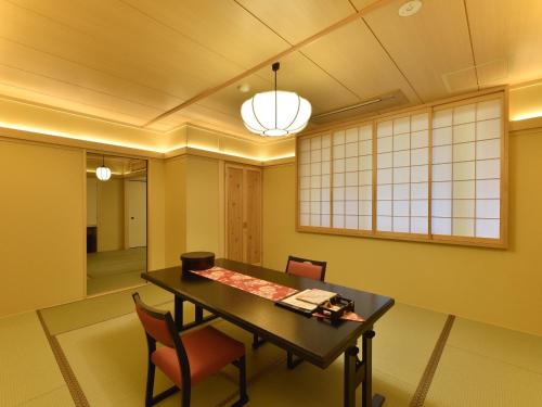 a dining room with a table and chairs at Matsui-Bekkan Hanakanzashi in Kyoto