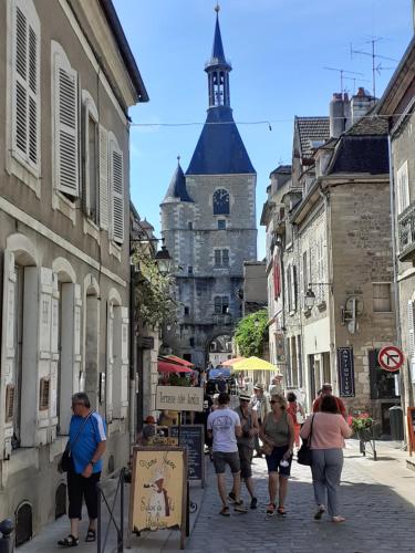 a group of people walking down a street with a castle at Appartement 48m2 pour 6 personnes au centre ville historique avec parking gratuit et une borne de recharge pour voiture à 10 metres in Avallon