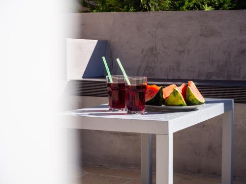 a table with a drink and a plate of fruit at Cypress Garden Villas in Svoronata