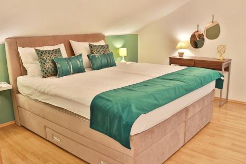 1 dormitorio con 1 cama grande con almohadas verdes en Villa Grand Pinea en Čilipi